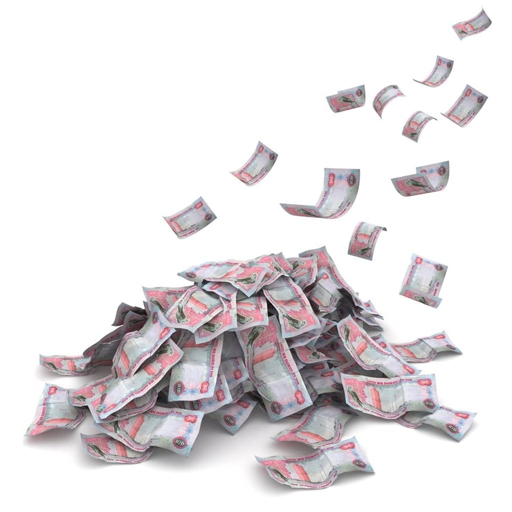 UAE Dirham bills falling into a pile of money.