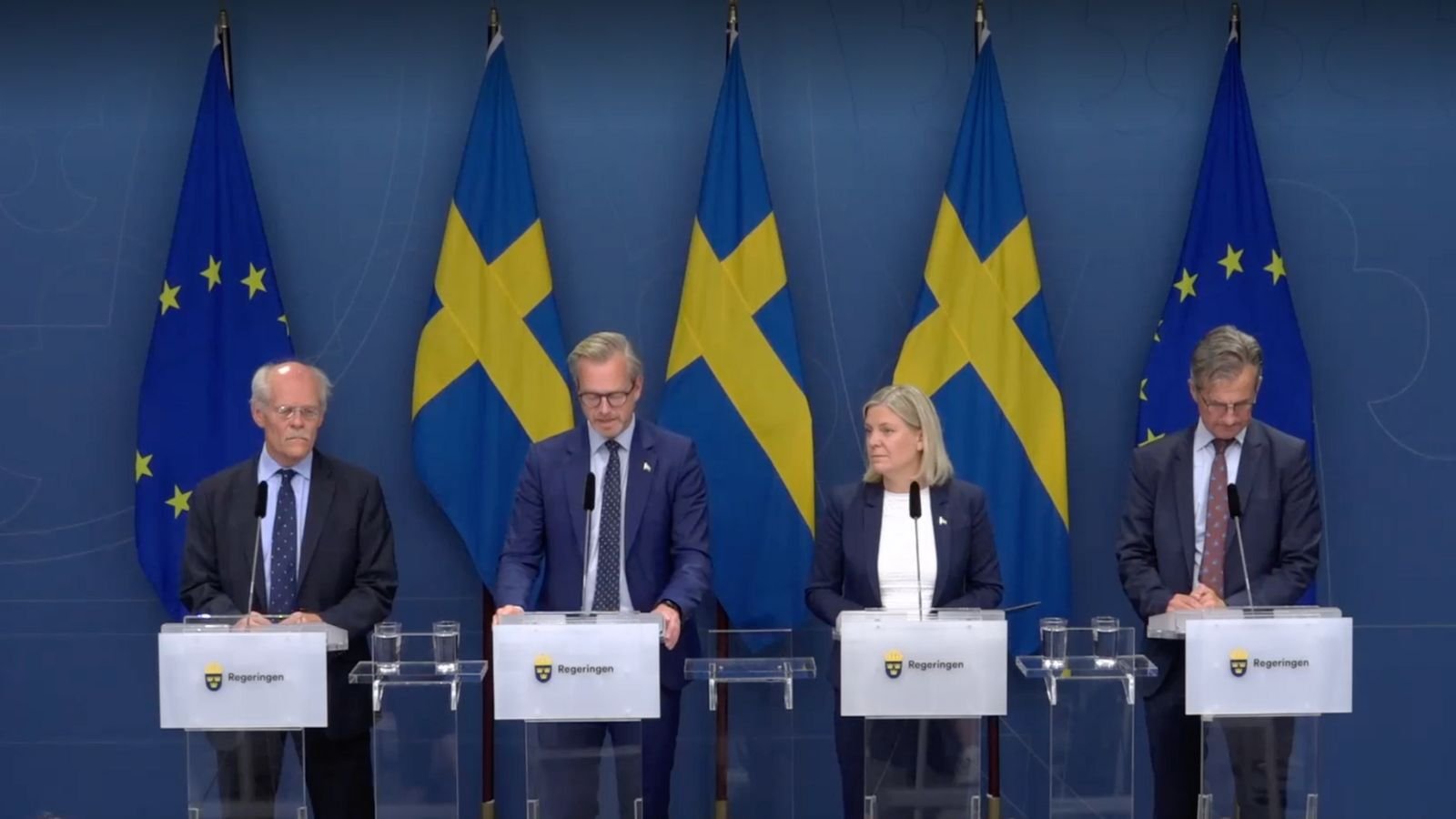 Magdalena Andersson with three governmental representatives at a press briefing. Swedish and EU flags behind them.